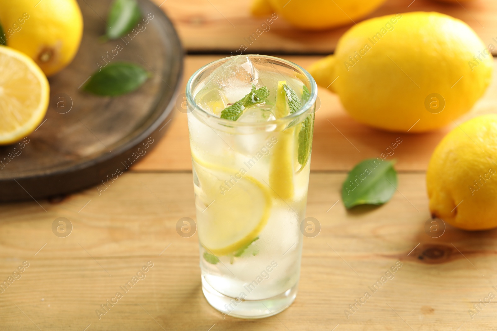 Photo of Cool freshly made lemonade and fruits on wooden table