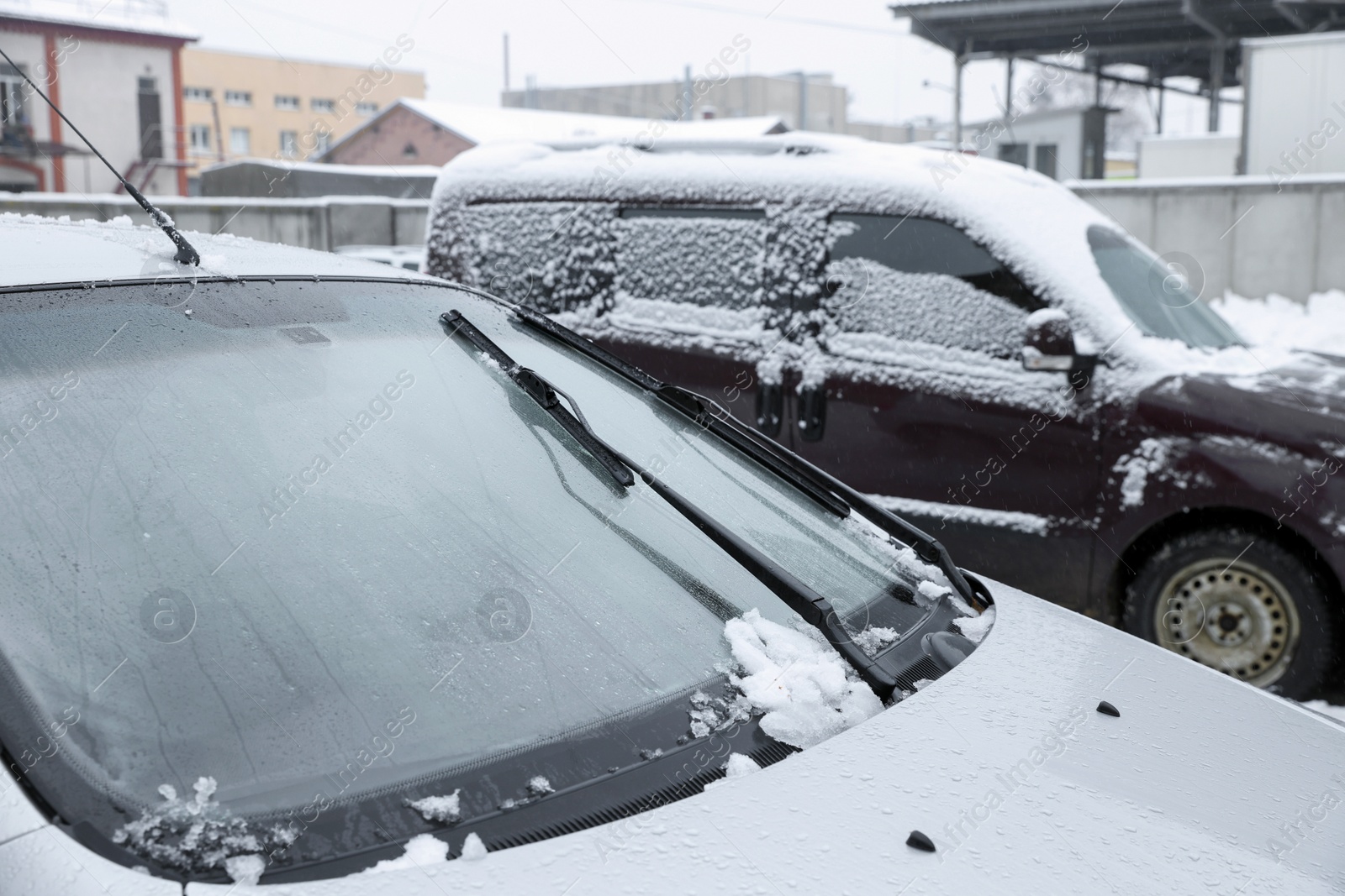 Photo of Car windshield with wiper blades cleaned from snow outdoors on winter day