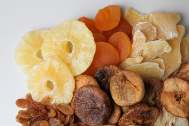 Photo of Pile of different dried fruits on white background, top view