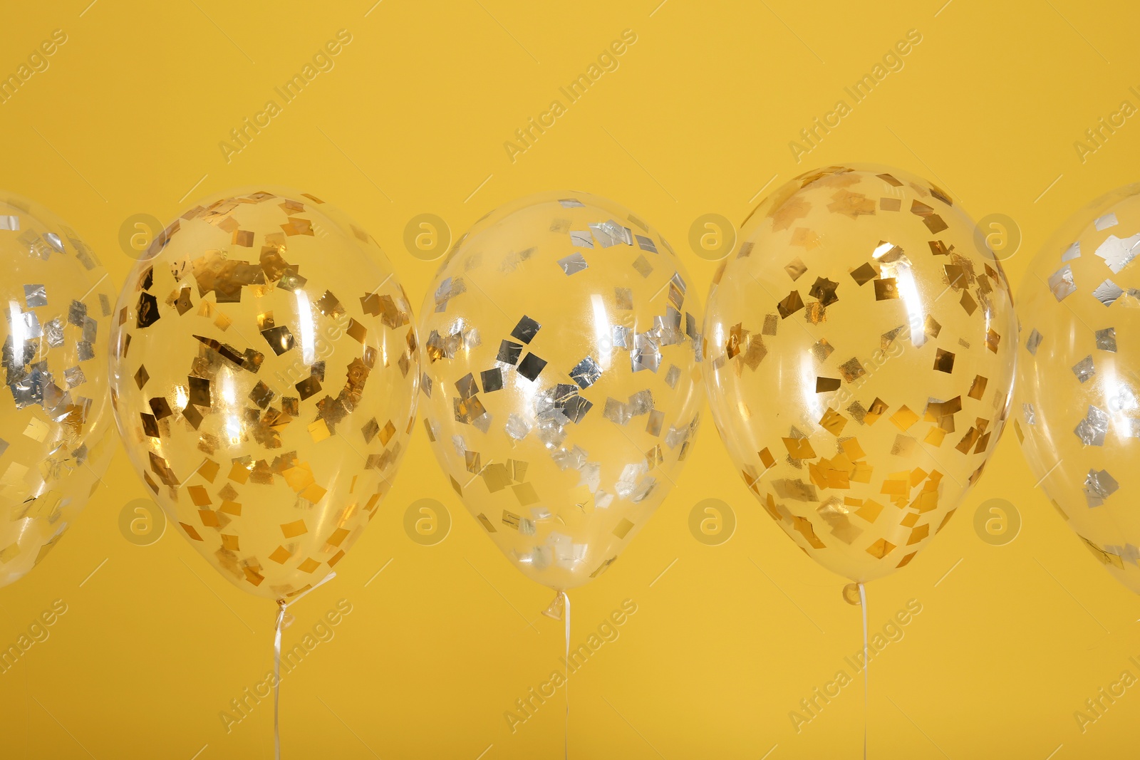 Photo of Bright balloons with ribbons on color background