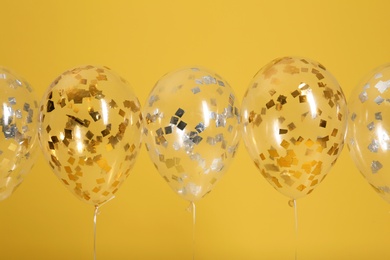 Bright balloons with ribbons on color background