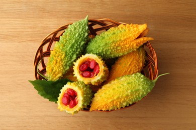 Basket with bitter melons on wooden table, top view