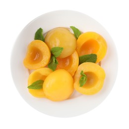 Halves of canned peaches with mint leaves isolated on white, top view