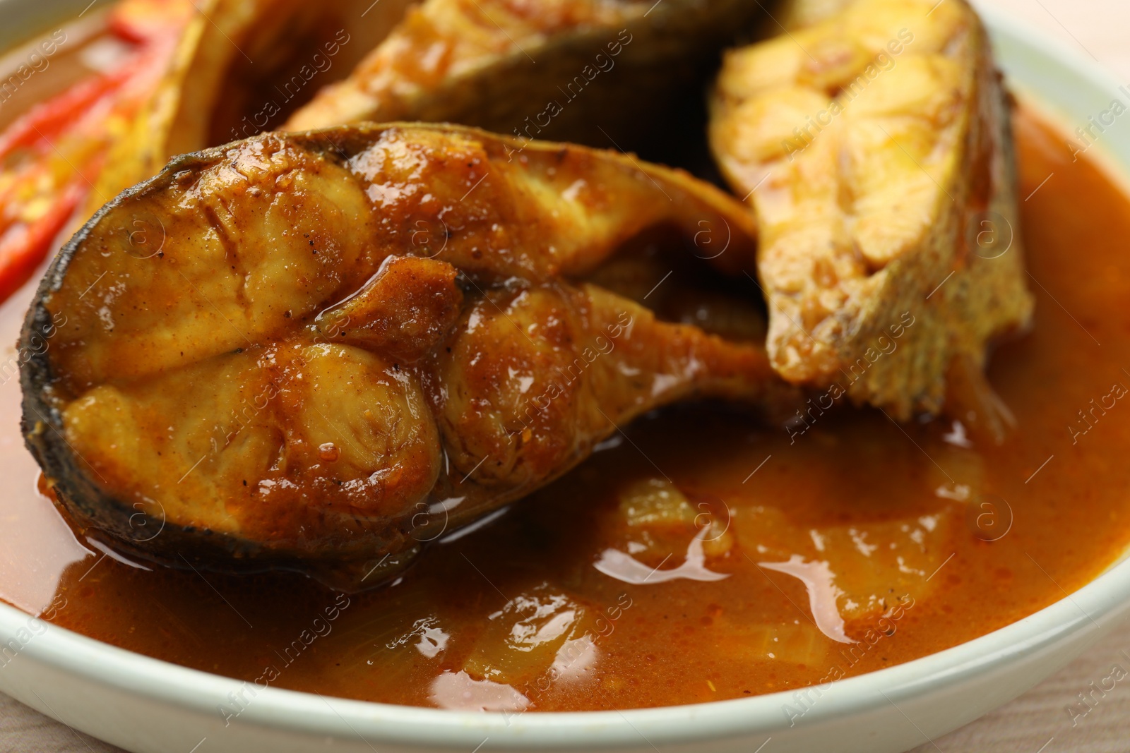 Photo of Tasty fish curry on plate, closeup. Indian cuisine