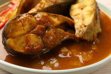 Tasty fish curry on plate, closeup. Indian cuisine