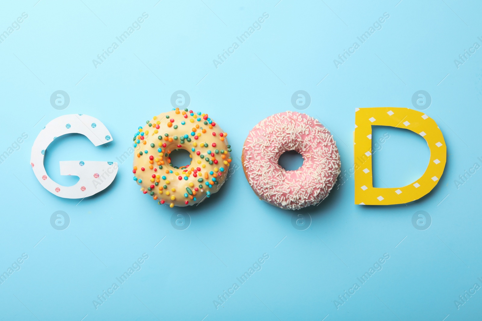 Photo of Word GOOD made with donuts and carton letters on light blue background, flat lay