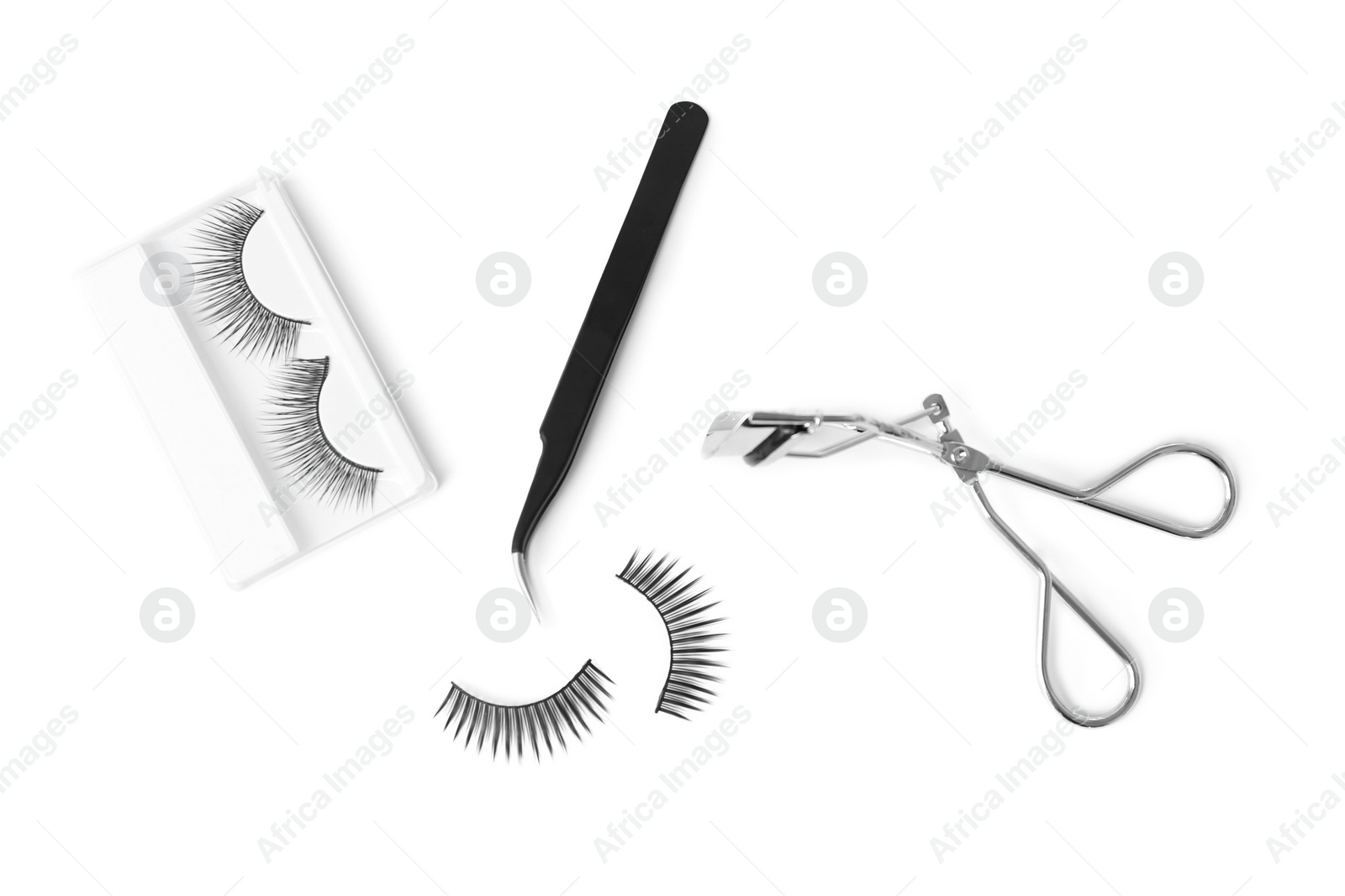 Photo of False eyelashes, tweezers and curler on white background