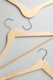 Wooden hangers on light gray background, flat lay