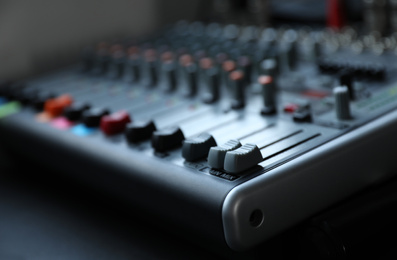 Photo of Modern audio mixing console, closeup. Music equipment