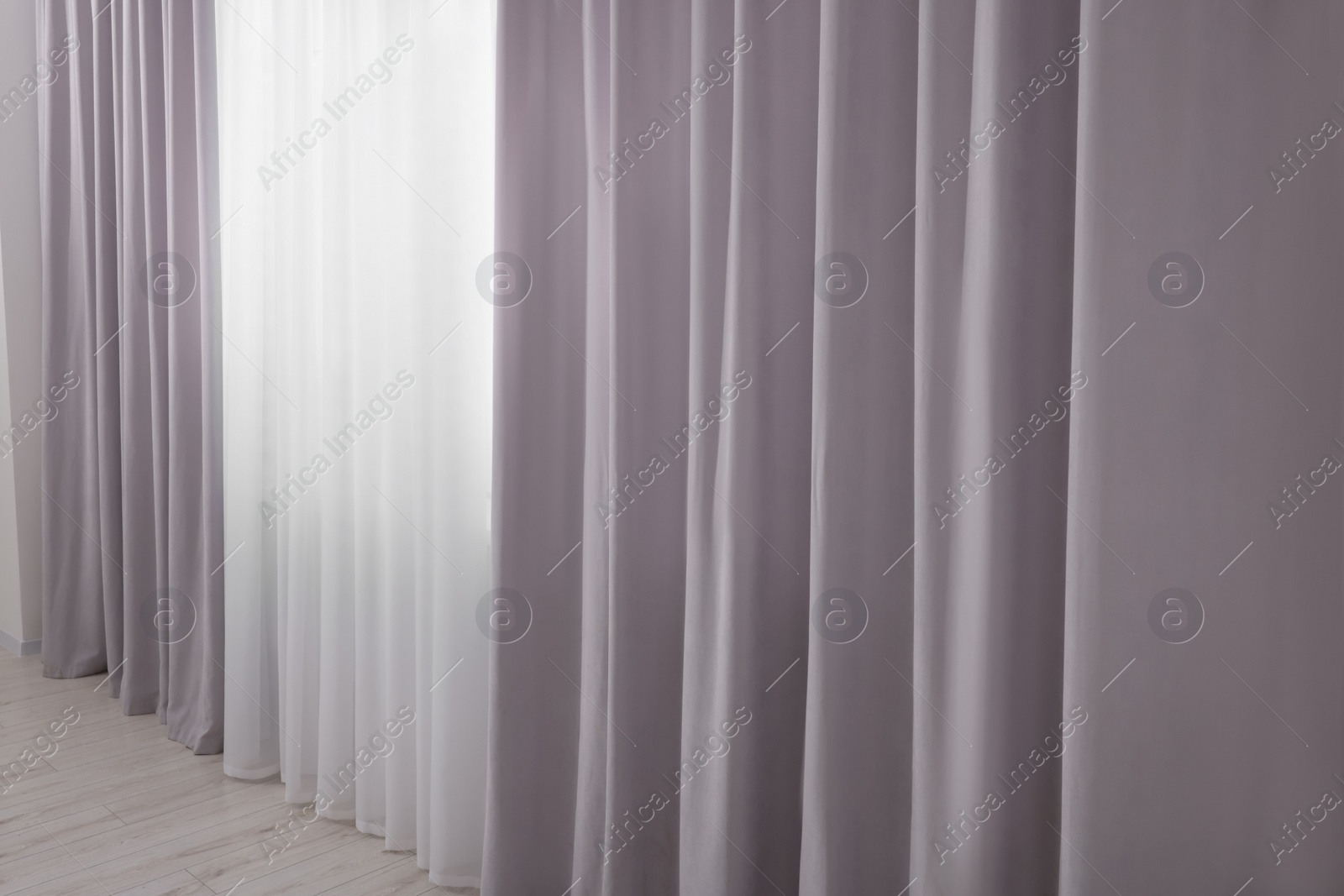 Photo of Light grey window curtains and white tulle indoors