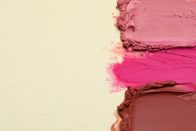 Smears of beautiful lipsticks on beige background, top view. Space for text