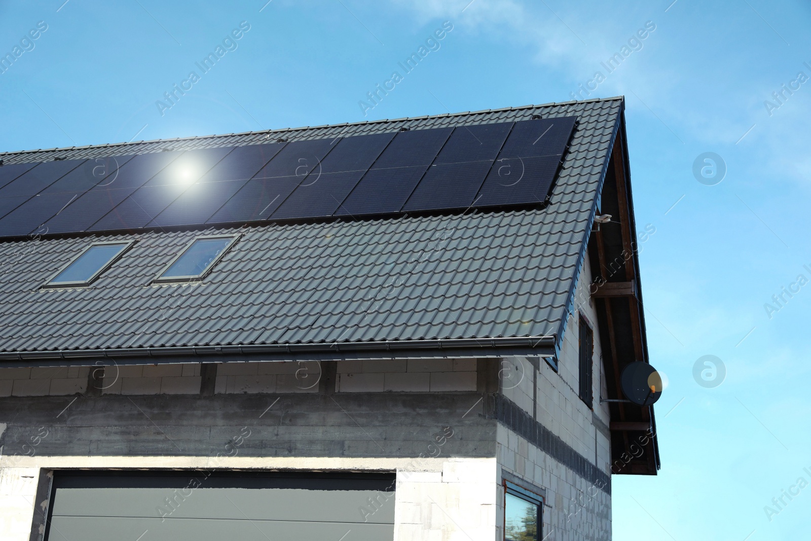 Photo of House with installed solar panels on roof. Alternative energy