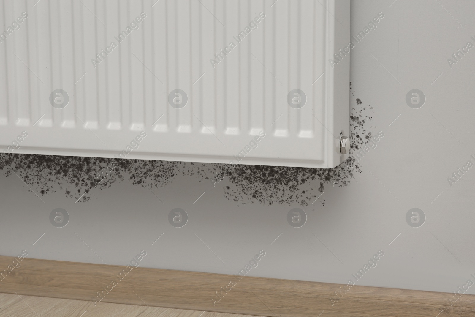 Image of Mold around panel radiator on wall in room