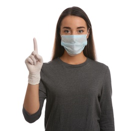Photo of Woman in protective mask and medical gloves with raised index finger on white background
