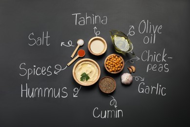 Photo of Delicious hummus, ingredients and chalk written products names on black background, flat lay