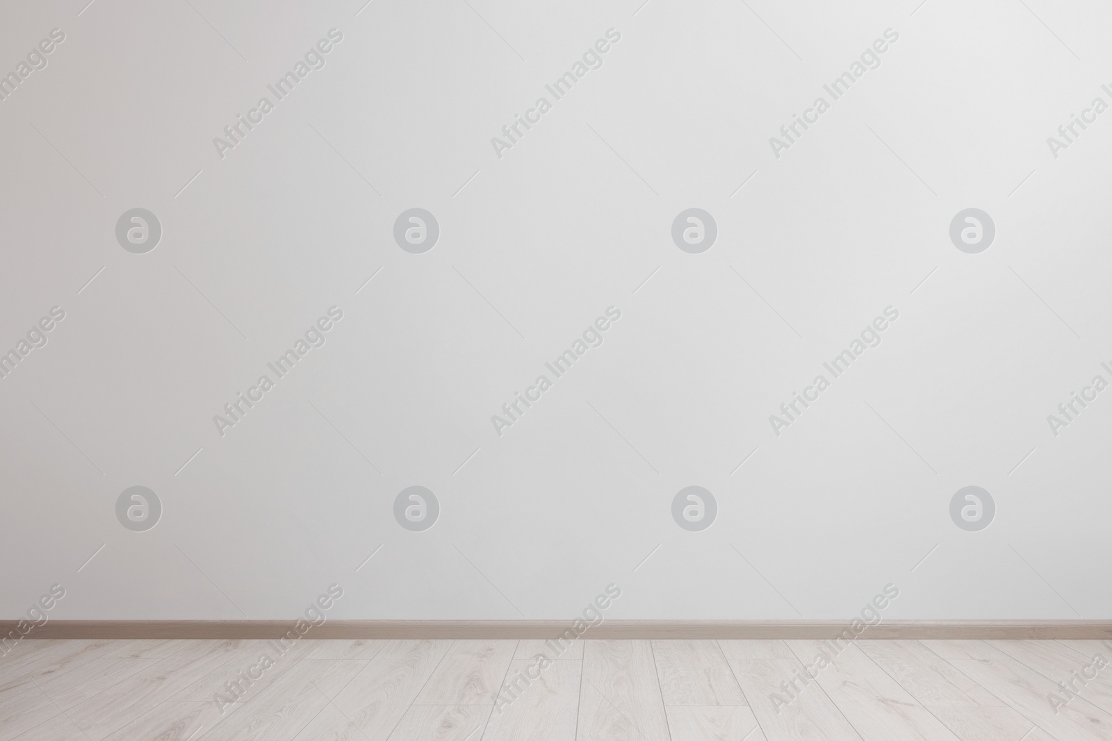 Photo of Empty room with white wall and wooden floor