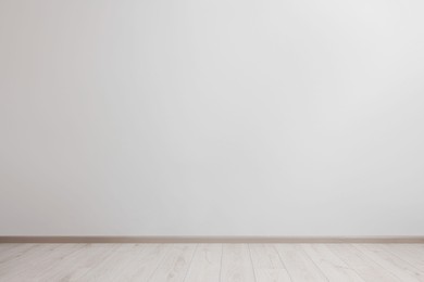 Empty room with white wall and wooden floor