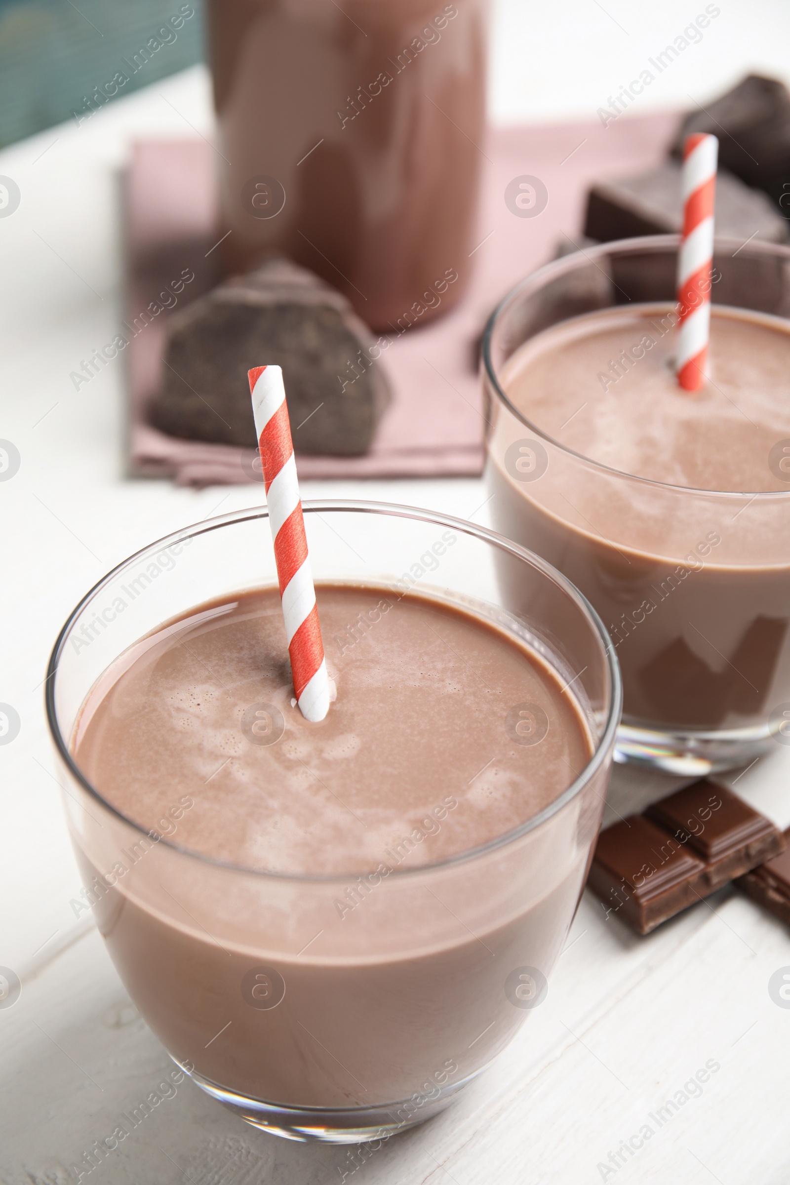 Photo of Delicious chocolate milk on white wooden table