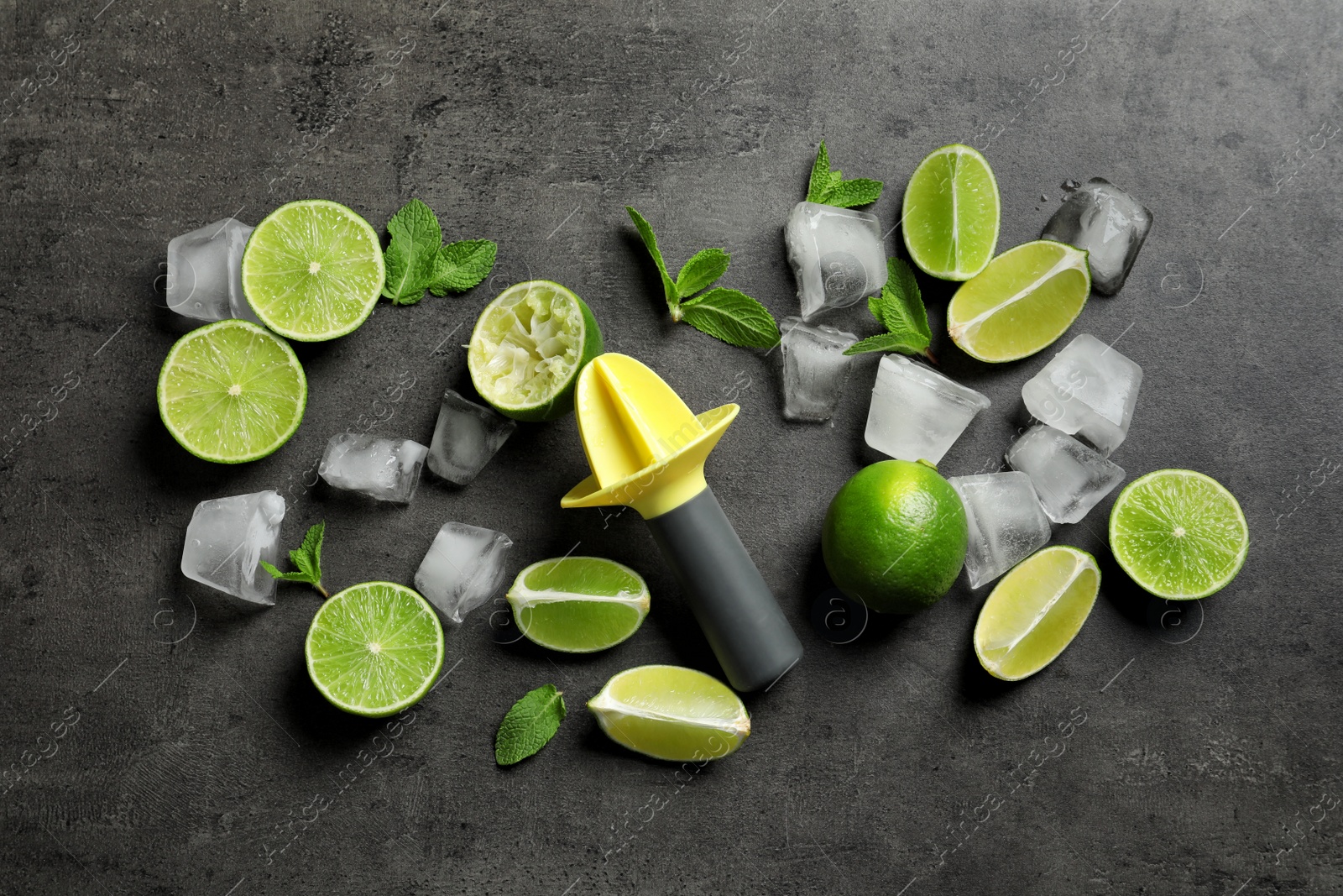 Photo of Flat lay composition with lime, mint and juicer on grey background. Refreshing beverage ingredients