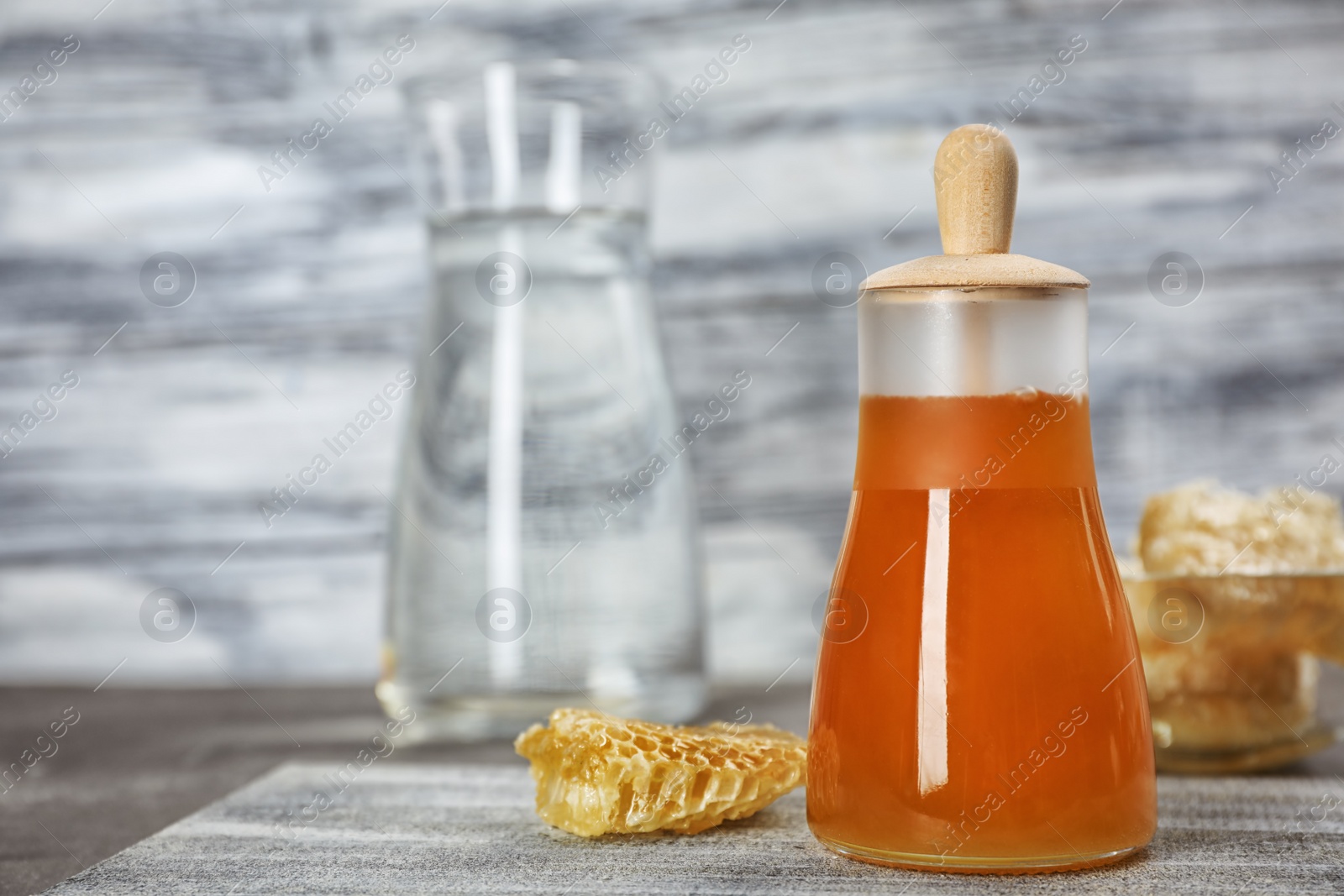 Photo of Jar of honey and honeycombs on table