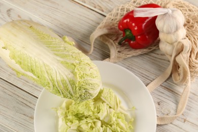 Photo of Fresh Chinese cabbage, bell pepper and garlic on wooden table