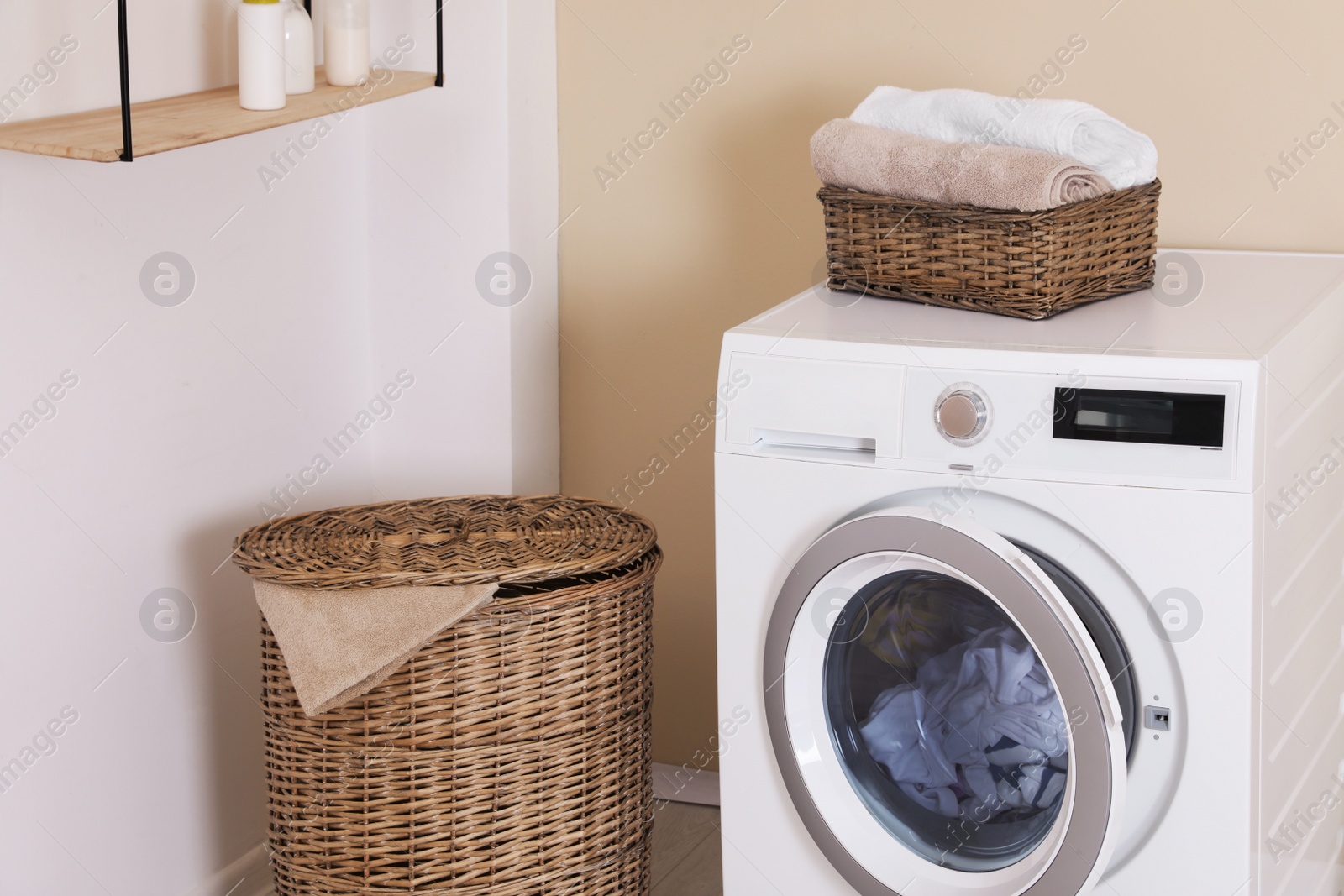 Photo of Laundry room interior with washing machine near wall