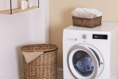 Laundry room interior with washing machine near wall