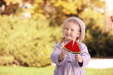 Cute little girl with tasty candies outdoors