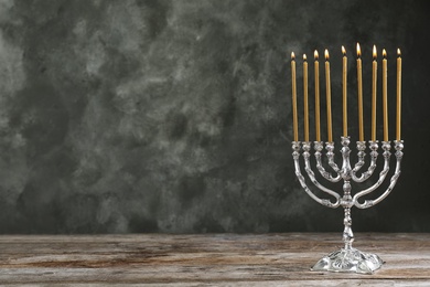 Photo of Hanukkah menorah on table against grey background