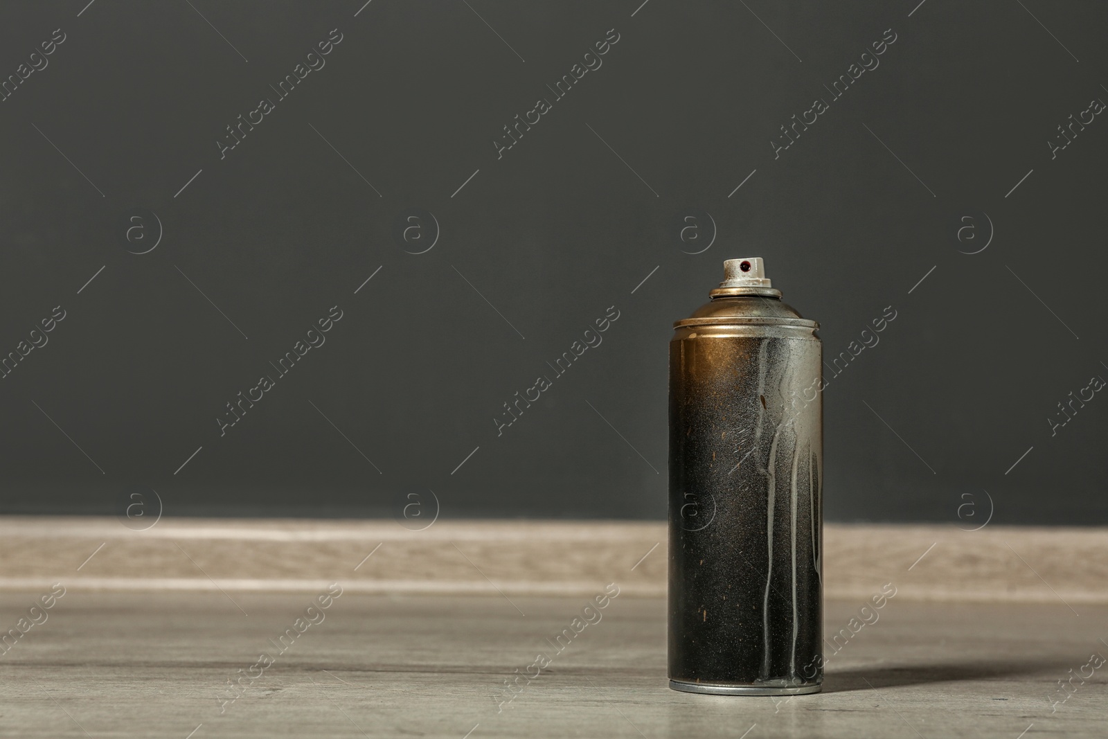 Photo of Used can of spray paint on floor indoors. Space for text