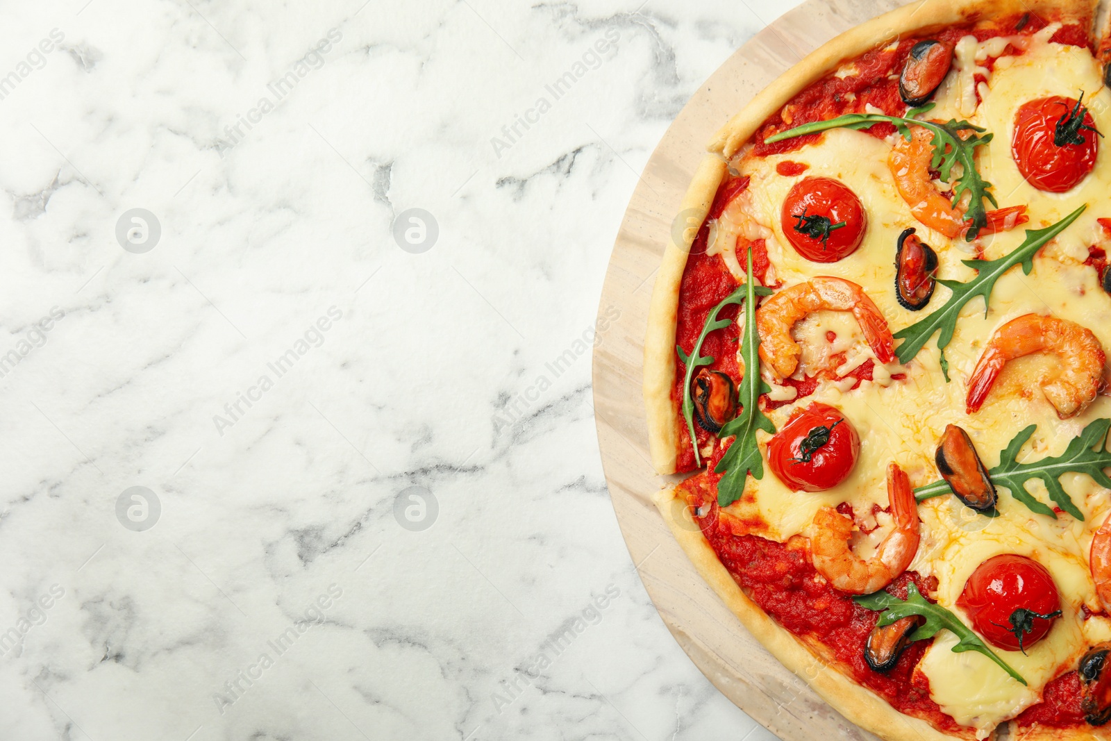 Photo of Delicious seafood pizza on white marble table. Space for text