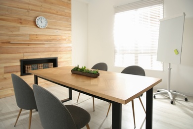 Photo of Modern meeting room interior with large table and chairs