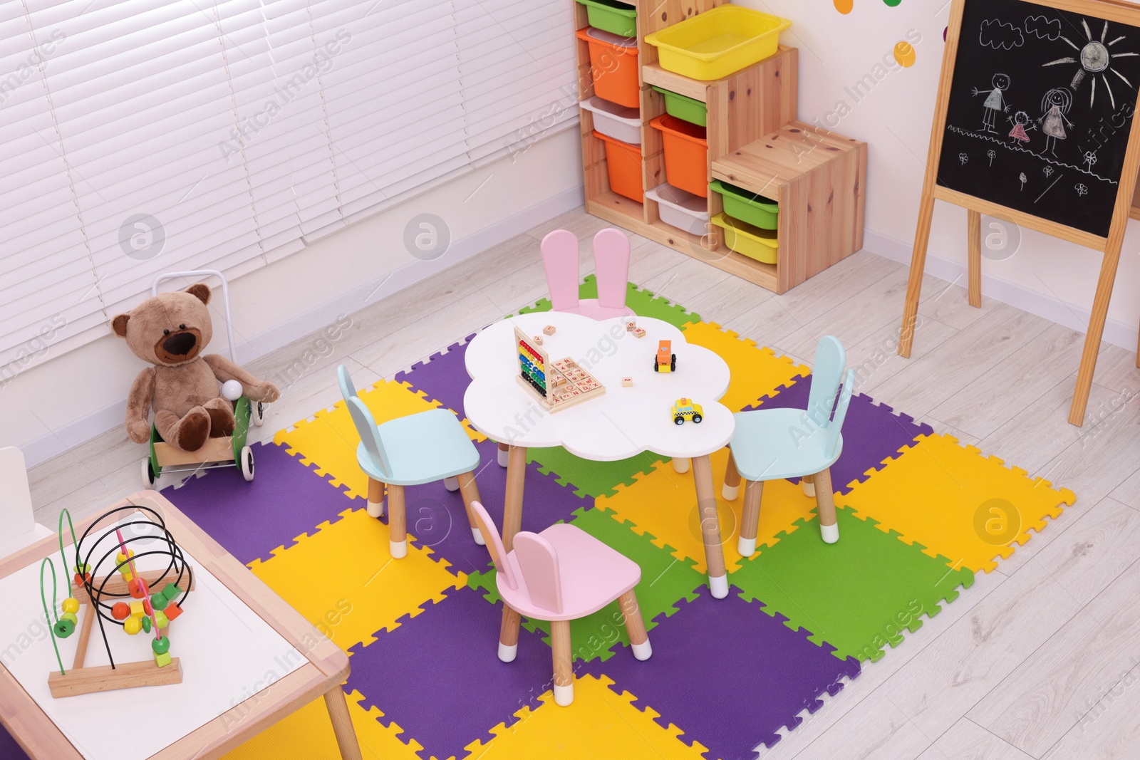 Photo of Stylish kindergarten interior with toys and modern furniture, above view