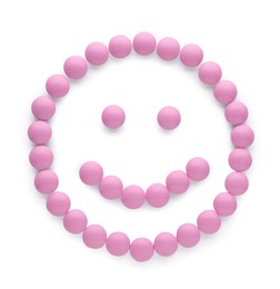 Happy face made of pink antidepressant pills isolated on white, top view