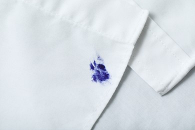Stain of blue ink on white shirt, top view