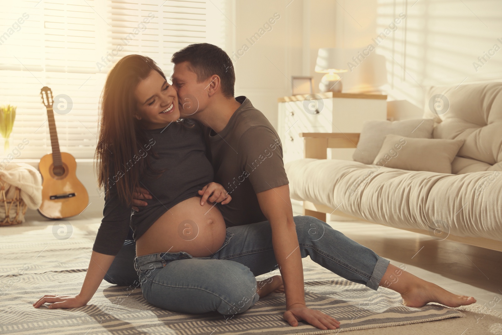 Photo of Young pregnant woman with her husband at home