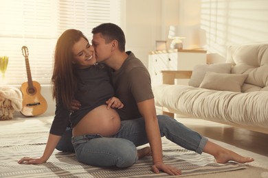 Young pregnant woman with her husband at home