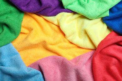 Photo of Many colorful microfiber cloths as background, closeup