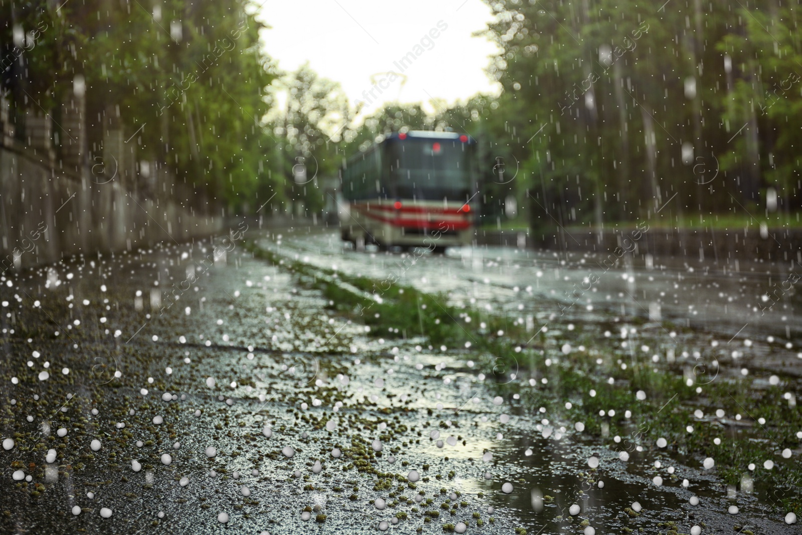 Image of View of tram on city street on rainy day with hail