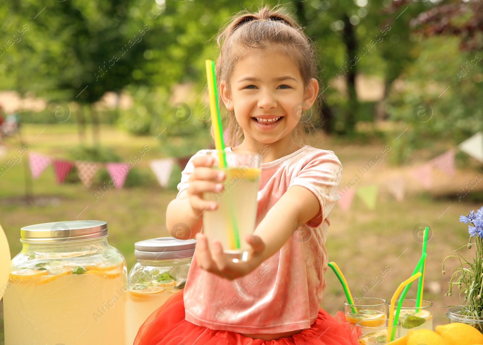 Photo of Little girl with natural lemonade in park