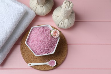 Photo of Flat lay composition with sea salt and herbal bags on pink wooden table. Space for text