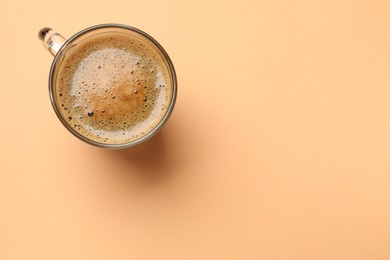 Photo of Fresh coffee in cup on beige background, top view. Space for text