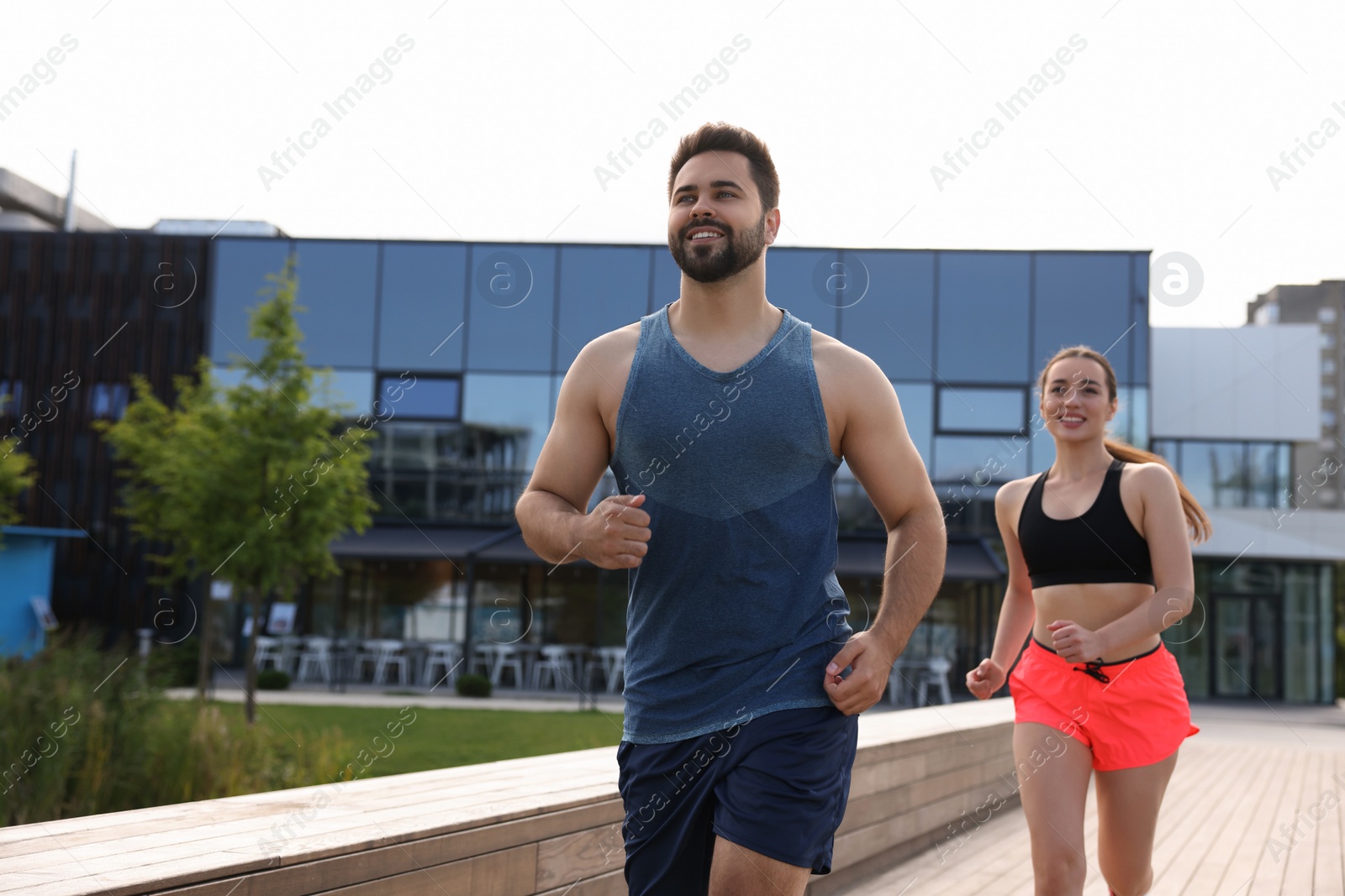 Photo of Healthy lifestyle. Happy couple running outdoors, space for text