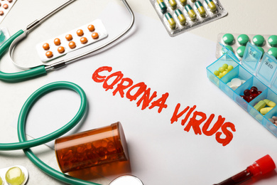 Photo of Phrase CORONA VIRUS and medicines on white background
