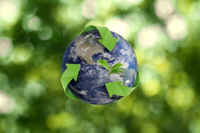 Recycling concept. Earth planet with green arrows and leaves on blurred background, illustration