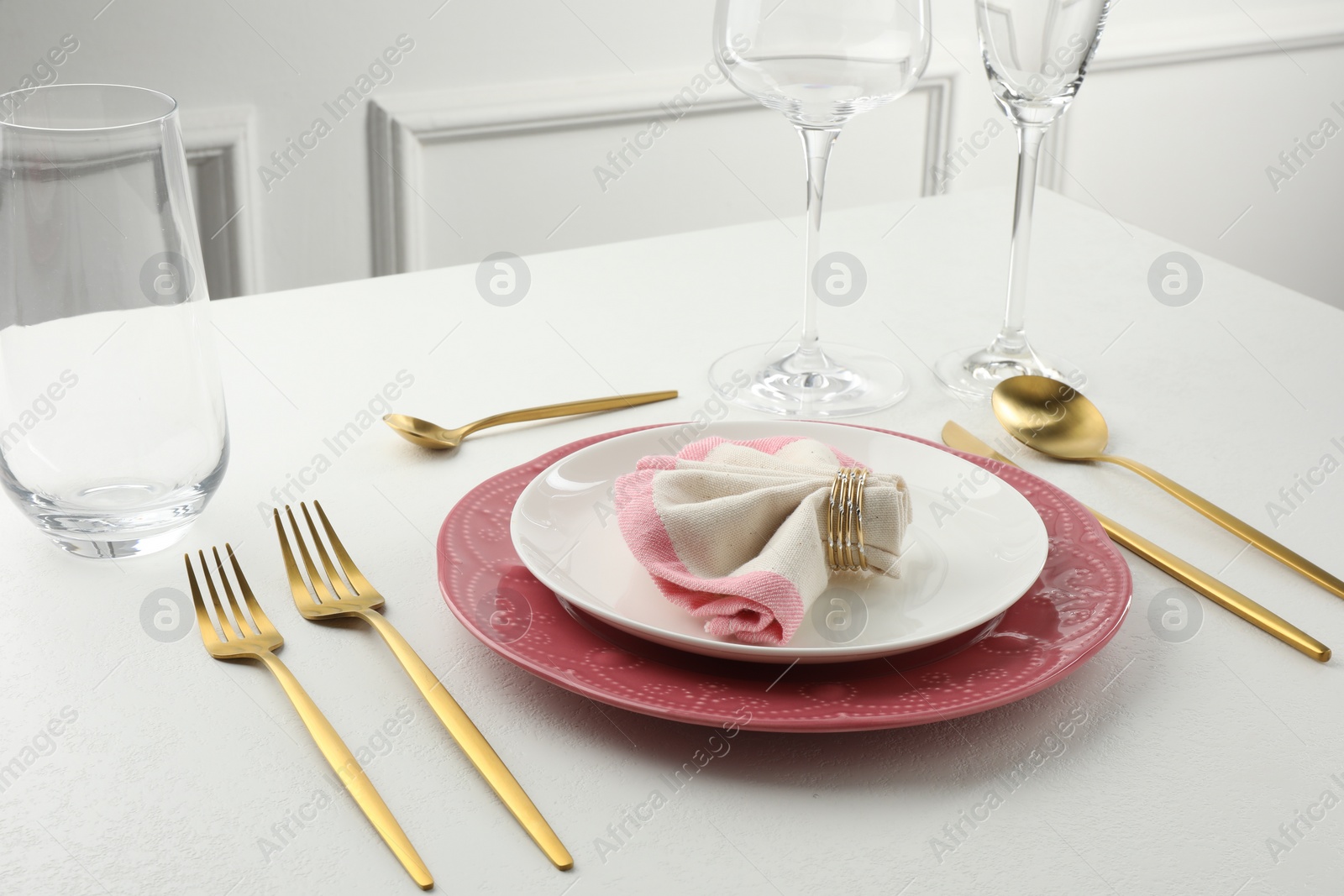 Photo of Stylish setting with cutlery, napkin and plates on white textured table