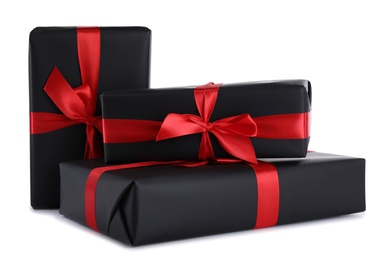 Photo of Black gift boxes with bows isolated on white