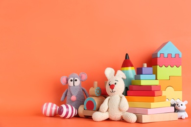 Photo of Set of different toys on orange background. Space for text