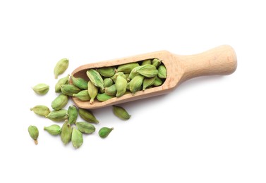 Photo of Wooden scoop with dry cardamom seeds on white background, top view
