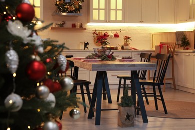 Photo of Cozy dining room interior with Christmas tree and beautiful festive decor